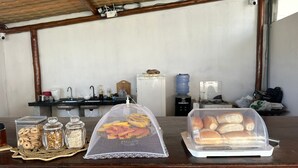 Angolo colazione con distributore d'acqua, lavandino e macchina del caffè.