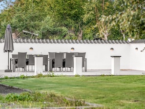 A patio with outdoor seating and a covered umbrella. - "Synne" - 350m from the sea by Interhome (Grenaa)