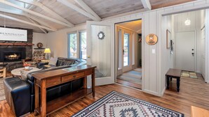 Ein gemütliches Wohnzimmer mit Kamin, Ledersofa, Couchtisch aus Holz und Teppich.
