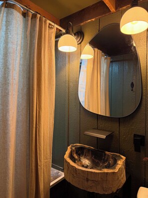 A bathroom with a wooden vanity, a round mirror, and a wooden basin. - Waterfront A- Frame With Dock, Canoe + Kayaks (Amanda)