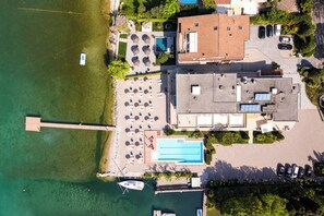 Ein Luftbild eines Anwesens mit Schwimmbad, Bootssteg und Parkplatz.