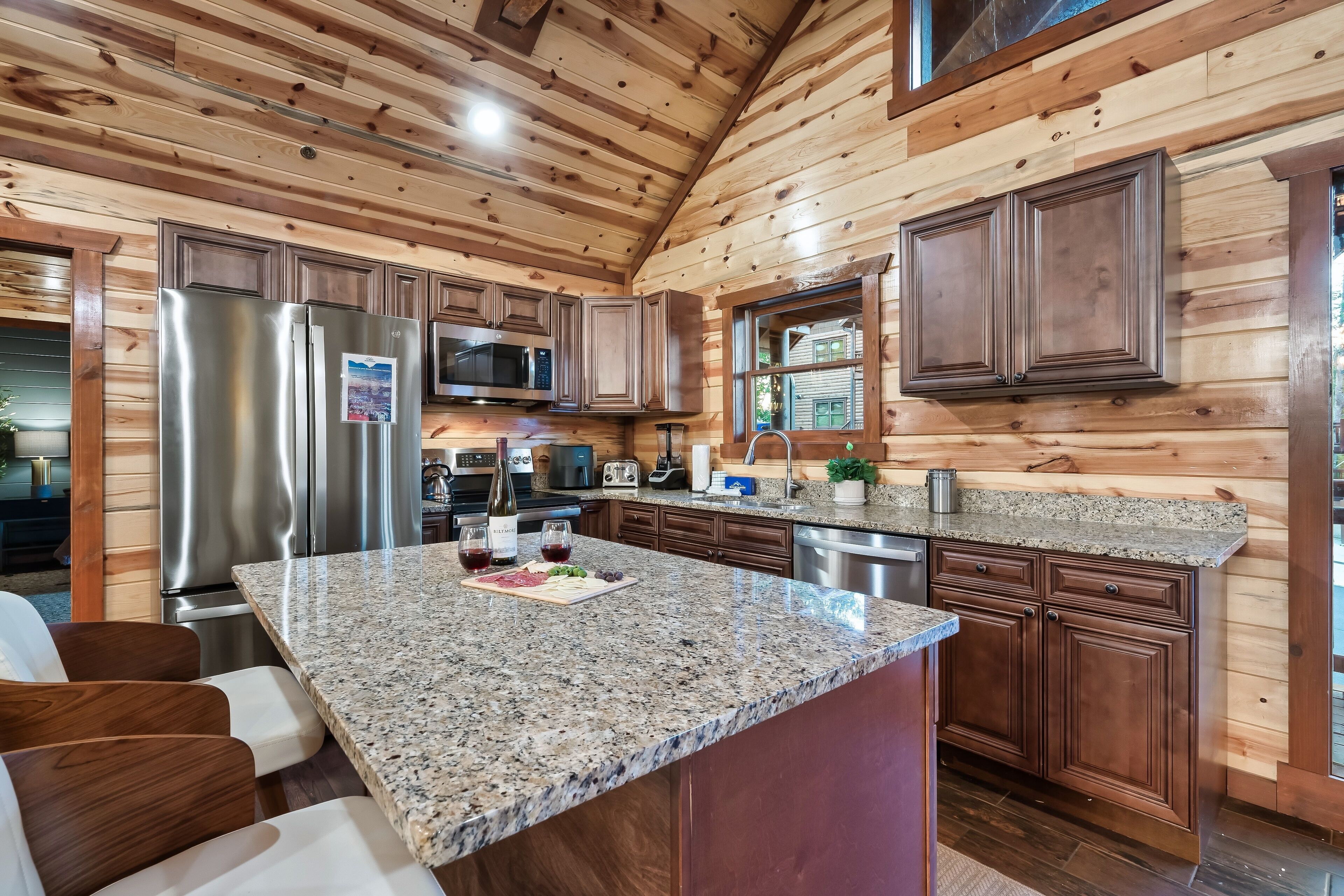 A modern kitchen with granite countertops, stainless steel appliances, and wooden cabinetry.