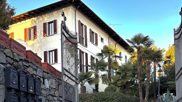 Un sentier pavé de pierres menant à un bâtiment doté d’un mur en pierre et de boîtes aux lettres.