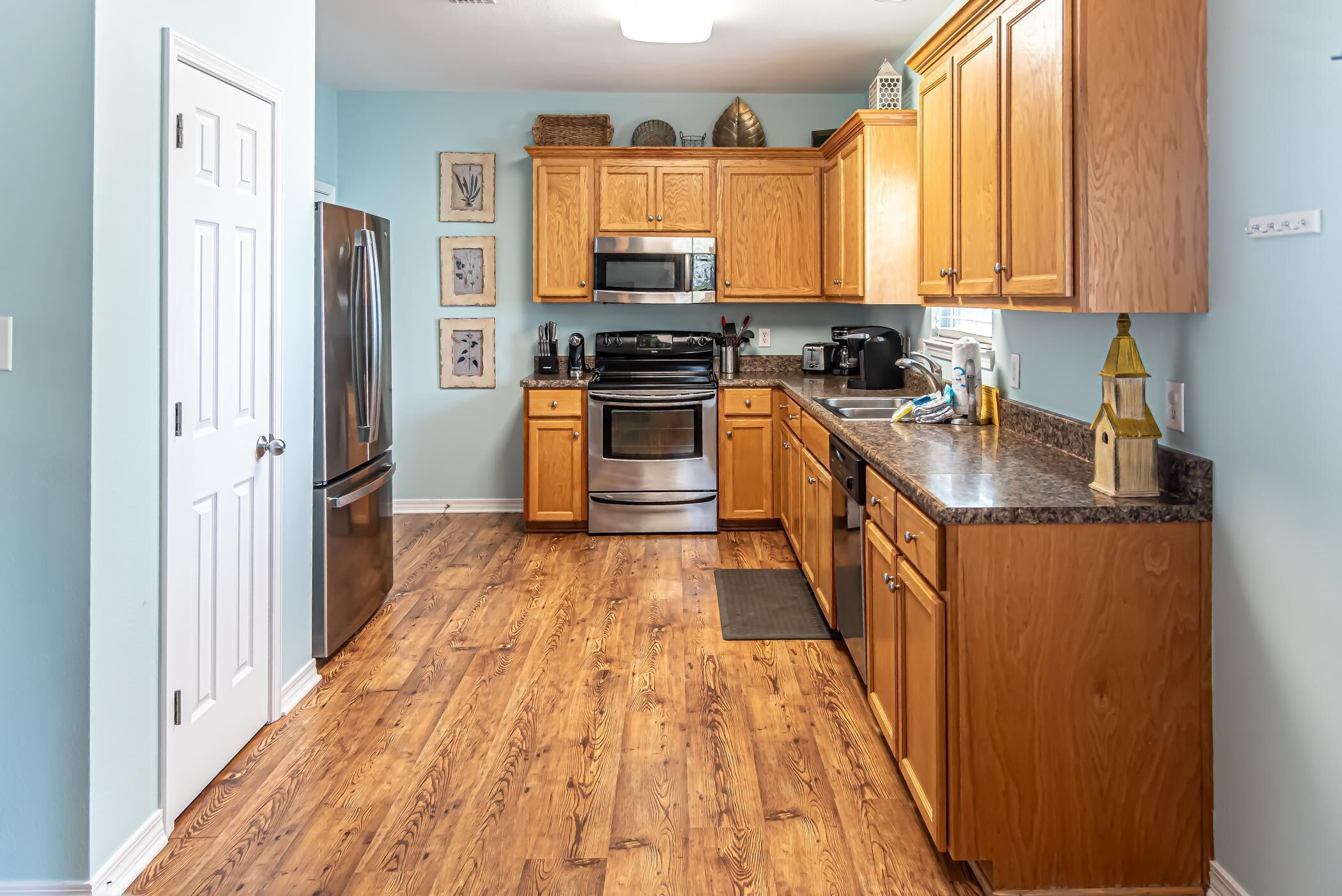 A kitchen with wooden cabinets, stainless steel appliances, and a granite countertop.