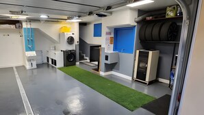 Un cuarto de lavandería con lavadora, secadora y estanterías.