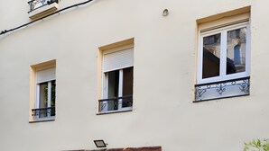 Un edificio con un letrero que dice 'La Perle Du Sancy', una puerta negra y plantas en macetas.