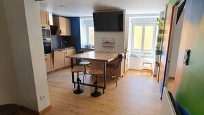 Una cocina moderna con armarios de madera, una isla central y un comedor con taburetes.