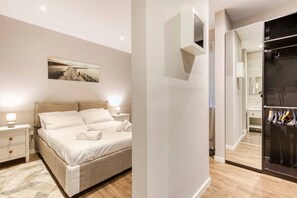 A modern bedroom with a large bed, bedside tables, a mirror, and a wardrobe. - Central Msida Apartment | Workspace, Wi-Fi & A/C (Msida)