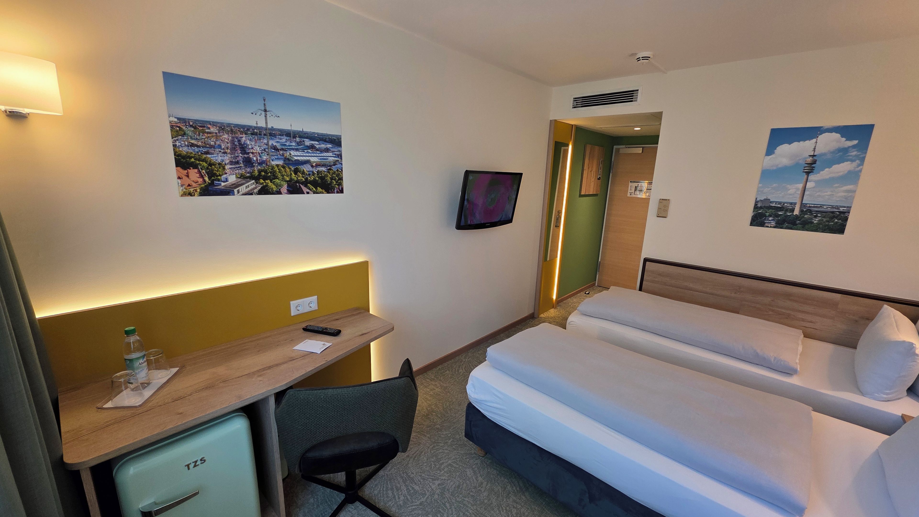 Une chambre d’hôtel équipée d’un lit, d’un bureau, d’une chaise et d’un téléviseur.