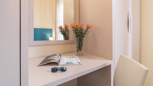 A bathroom with a white vanity, a mirror, a vase with flowers, a magazine, and a pair of sunglasses. - Elegant Sea View Apartment with Panoramic Patio (Grottammare)