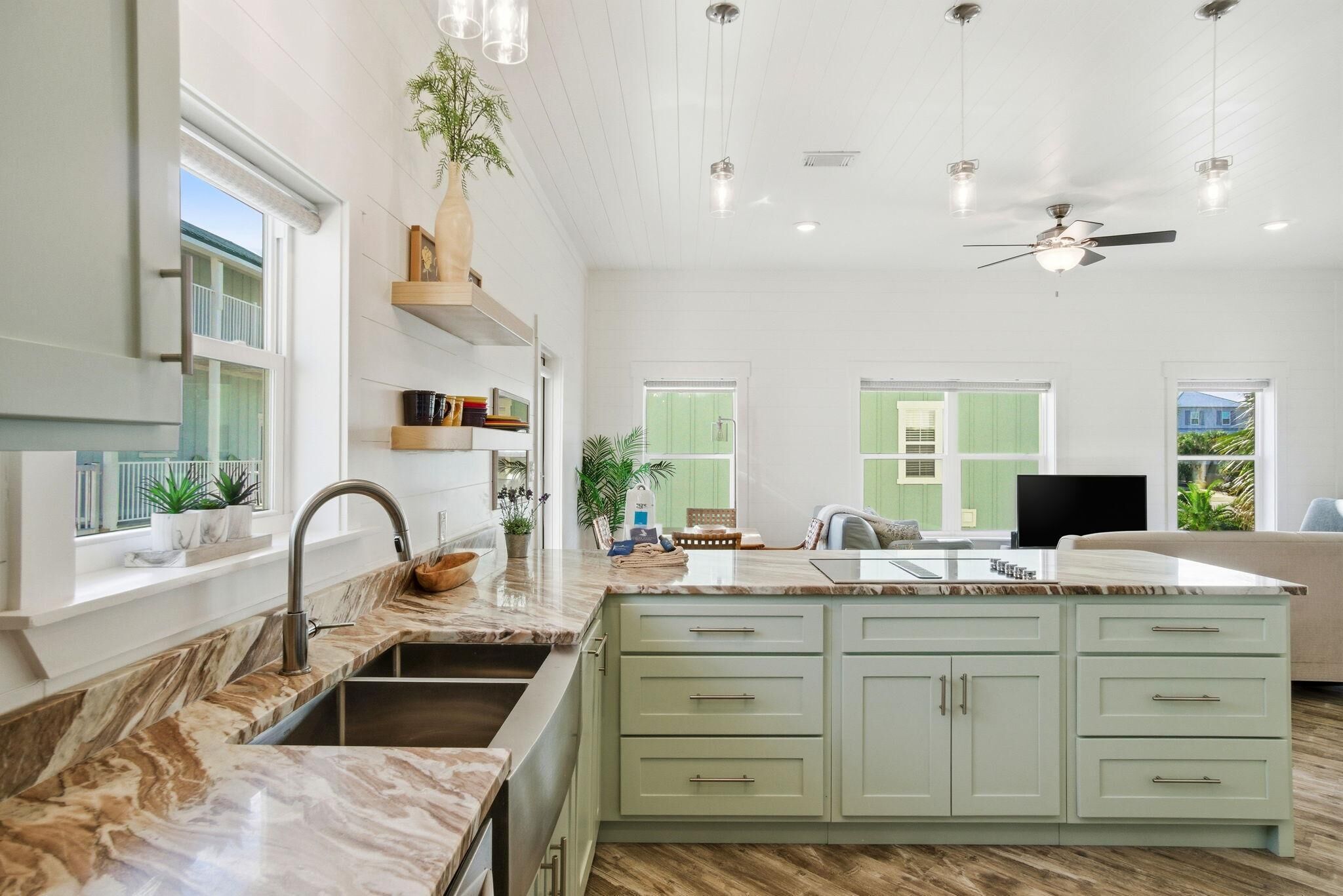 A spacious kitchen with a large island, built-in cabinets, and pendant lighting.