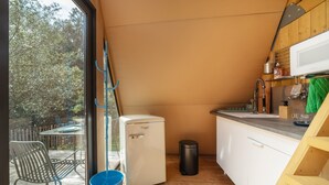 Eine kleine Küche mit Kühlschrank, Spüle und Holzschränken.