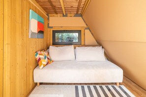 A small, cozy room with a bed, a window, and a wooden ceiling. - Tipi Lodge Glamp 'Marguerite' with Nordic Bath, Private Terrace, and Air Conditioning (Le Boulou)