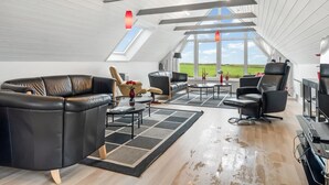 Un loft spacieux avec de hauts plafonds, de grandes fenêtres et une vue sur la campagne.