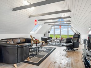 Un loft espacioso con techo alto, ventanas grandes y vistas al campo.