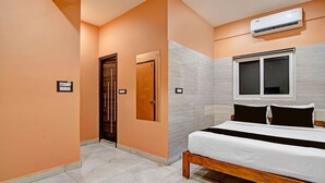 Un dormitorio con cama, aire acondicionado, ventana y puerta.