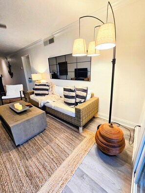 Ein modernes Wohnzimmer mit einer Couch, einem Couchtisch, einer Stehlampe und einem runden Tisch.
