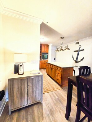 A kitchen with wooden cabinets, a dining table, and a TV.