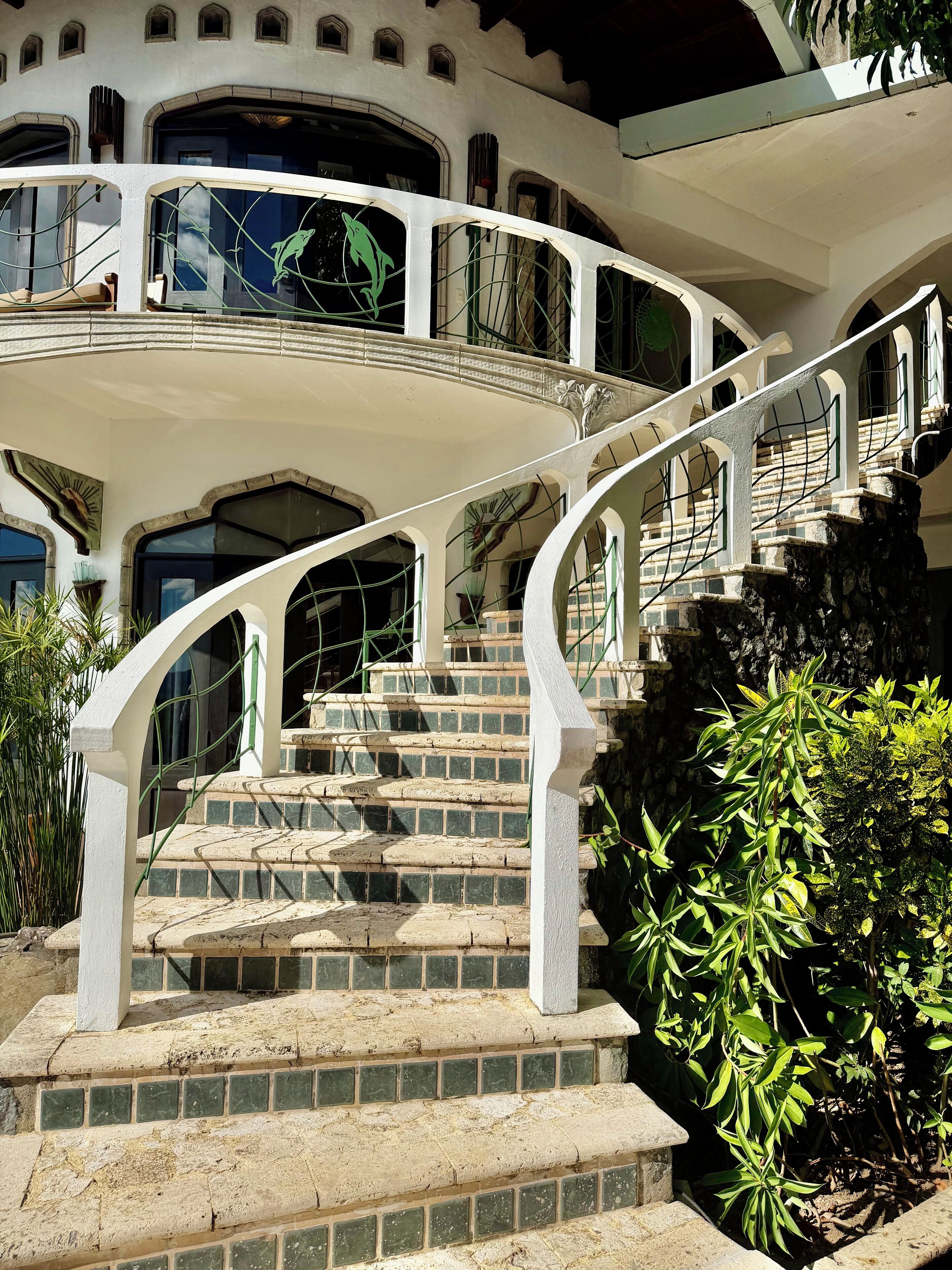 A grand staircase with a white balustrade leading to a second-floor balcony.