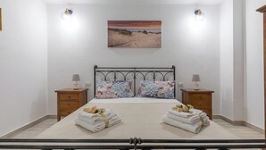 A neatly arranged bedroom with a bed, two nightstands, and a painting above the bed. - Dimora Aurea by BarbarHouse (Oria)