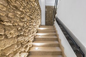 A staircase with beige steps and a stone wall on one side. - Vico Bianchi 5 by BarbarHouse (Brindisi)