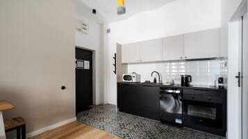 A compact kitchen with a microwave, toaster, sink, and oven.
