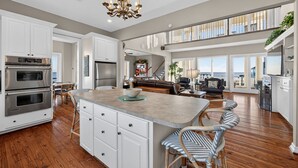 A spacious kitchen with a large island, stainless steel appliances, and a chandelier. - Beach Diamond - Gulf views, steps to the beach! (Galveston)