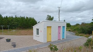 A small, single-story building with a gravel driveway and a paved path leading to it.