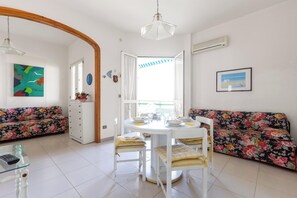 A dining area with a round table, chairs, and a sofa. - Villetta dei Tamerici by BarbarHouse (Gallipoli)