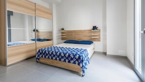 Ein modernes Schlafzimmer mit Bett, Schrank und Spiegel.