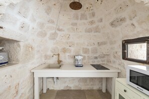 A compact kitchen with a white countertop, a coffee machine, and a microwave. - Tenuta Manfredi by Perle di Puglia (Francavilla Fontana)