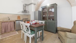 A compact kitchen with a dining table, chairs, a cabinet, and a sofa. - Il Gelsomino BIanco by BarbarHouse (Mottola)
