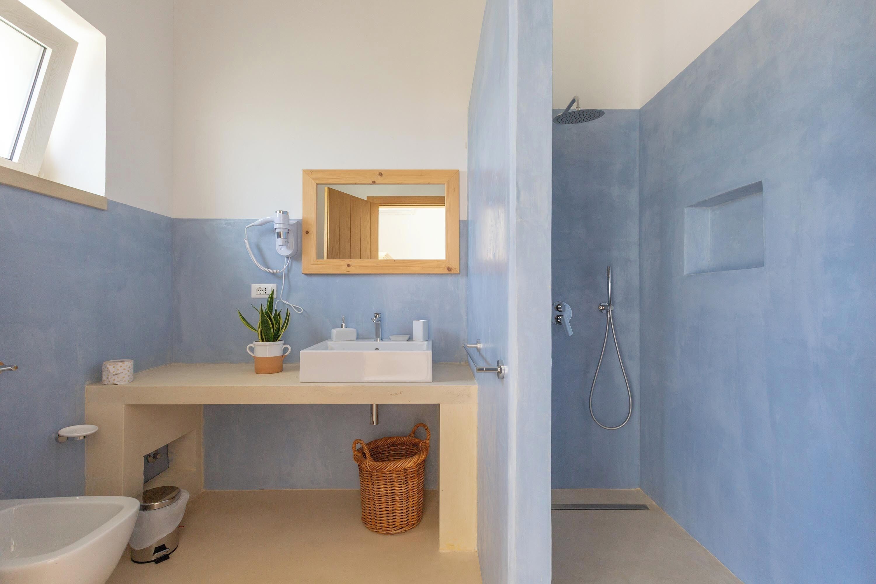 Une salle de bain avec un lavabo, un miroir et une douche.