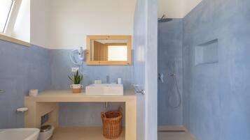 Une salle de bain avec un lavabo, un miroir et une douche.