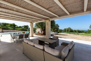 An outdoor patio with a pool, wicker furniture, and a view of the landscape. - Villa Matilda by Perle di Puglia (Ostuni)