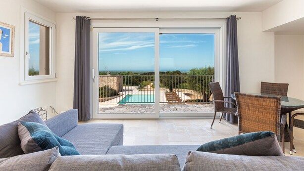 Ein Balkon mit Pool, Esstisch und einer Sitzecke.