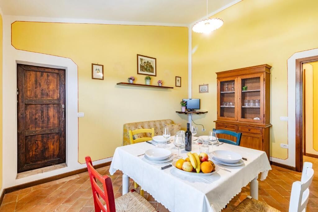 Un comedor con una mesa dispuesta para cuatro personas, un armario de madera y una puerta.