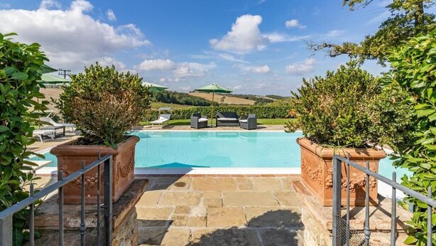A swimming pool with lounge chairs and a view of the countryside. - Agriturismo Rebarco (Castelfiorentino)