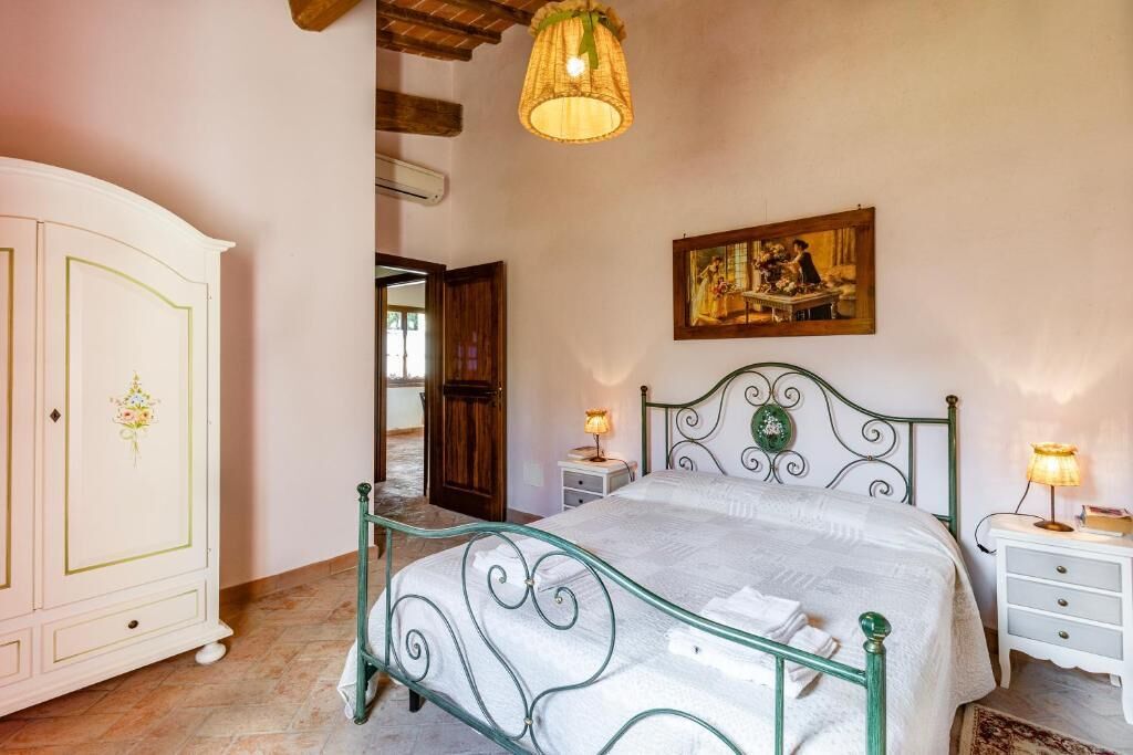 Une chambre à coucher avec un lit, des tables de chevet, une armoire et un tableau au mur.