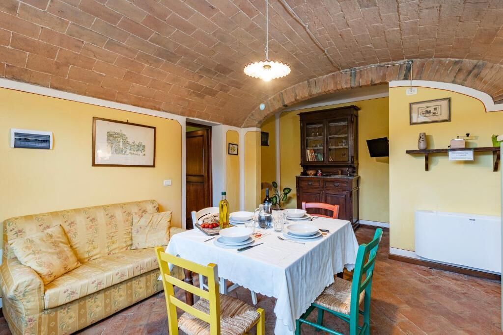 Un coin repas avec une table dressée pour quatre personnes, un canapé et un meuble en bois.