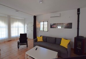 A living room with a sofa, a chair, a coffee table, and a fireplace. - Cozy casita in the countryside with swimming pool, near Málaga (Almogía)