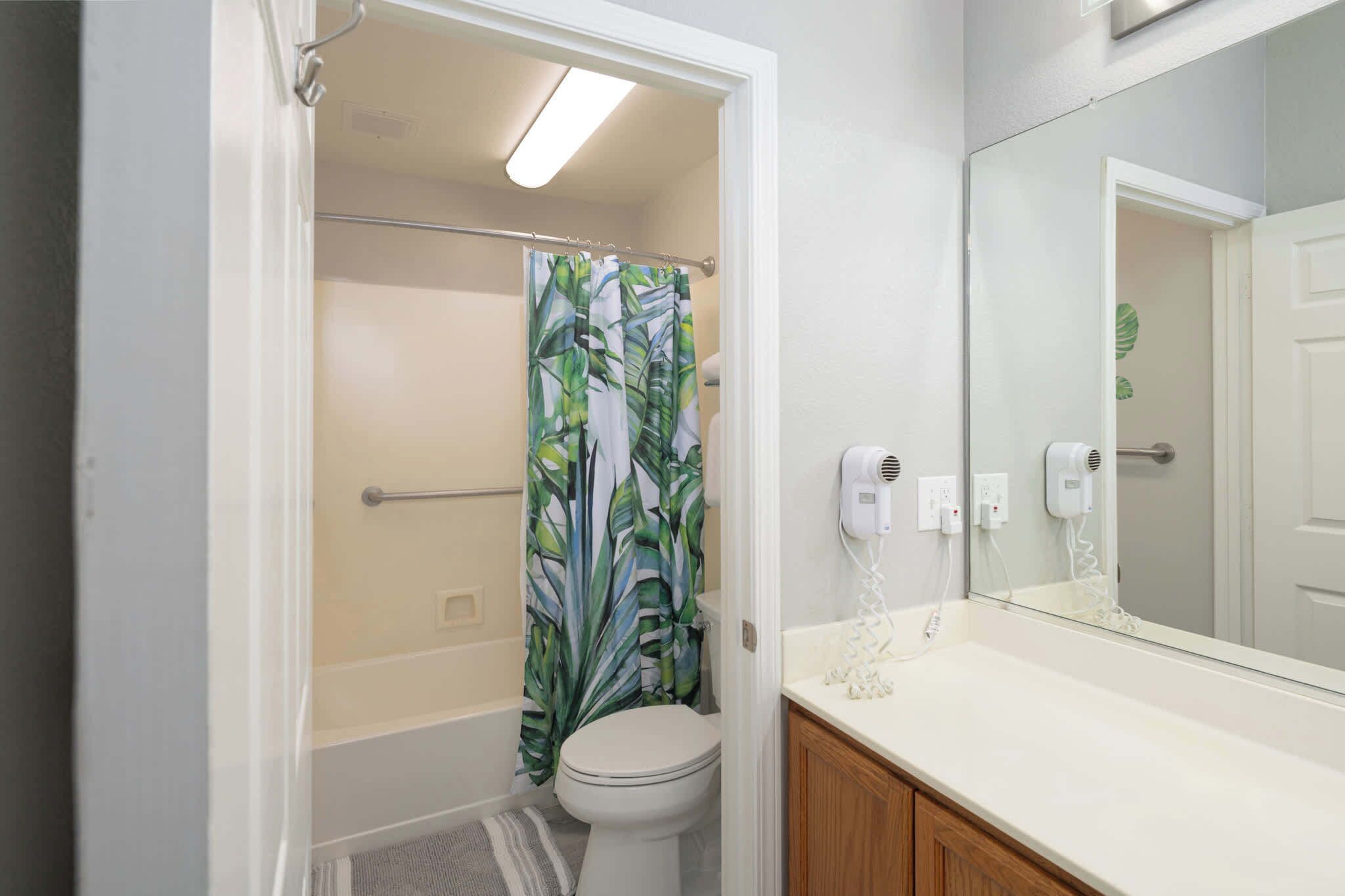 Une salle de bain équipée d’une douche, de toilettes et d’un meuble-lavabo avec un miroir.