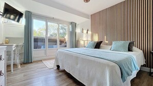 Ein Schlafzimmer mit einem großen Bett, einem Schreibtisch und einem Fernseher.