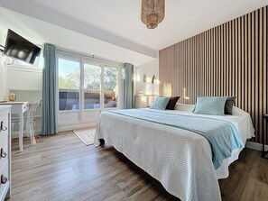 A bedroom with a large bed, a desk, and a television. - Gite Jade - Four Bedroom House, Sleeps 8 (Samois-sur-Seine)