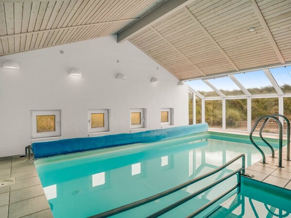 A swimming pool with a wooden ceiling, white walls, and a view of the outdoors. - "Nimrod" - 70m from the sea by Interhome (Thisted)