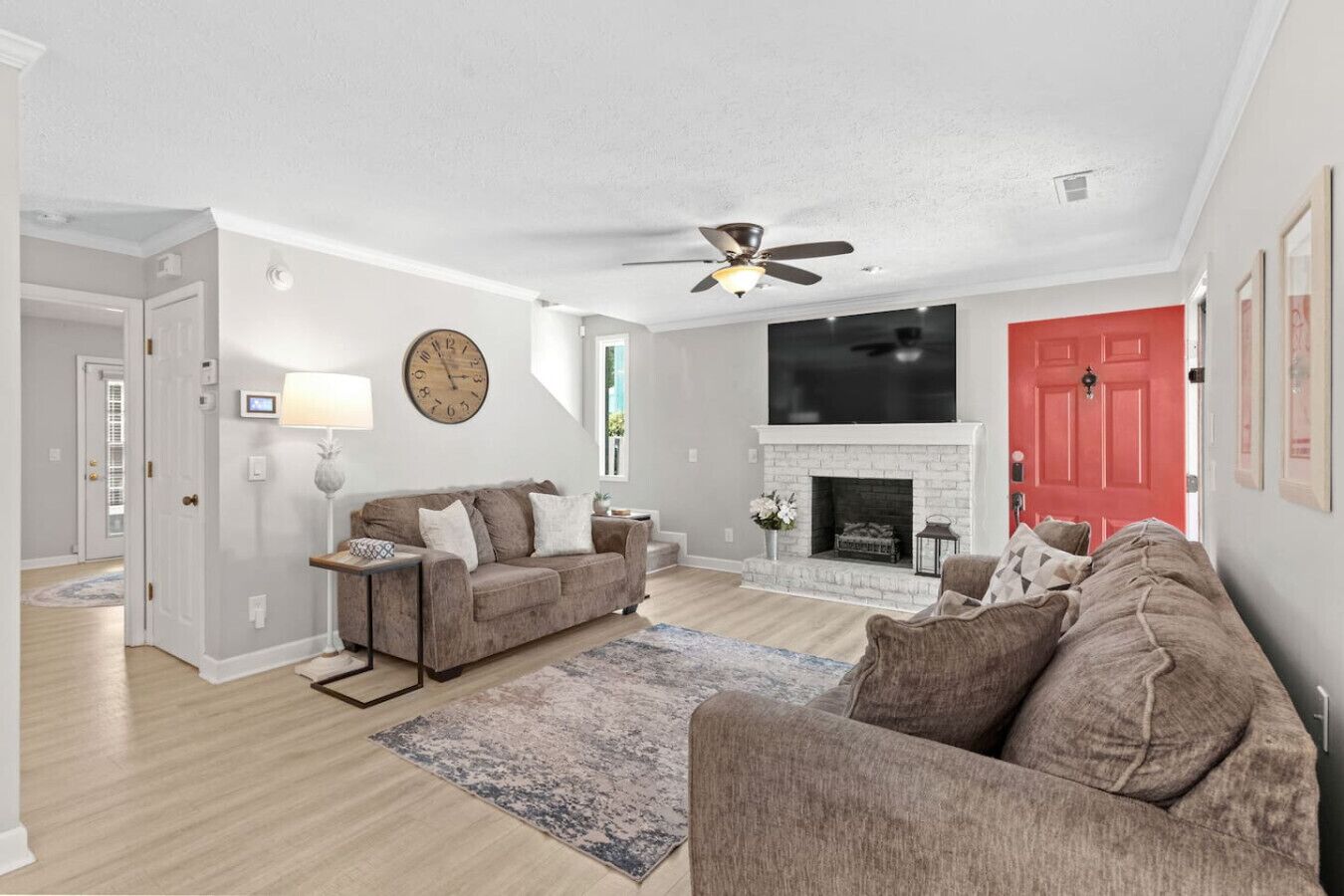 A living room with a fireplace, a sofa, a coffee table, and a clock on the wall.