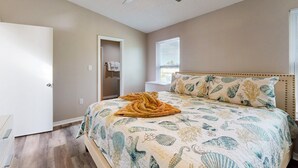 Camera da letto con un letto, una ventola a soffitto, una finestra e una porta.