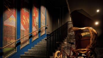 A staircase with a wooden bicycle and a wooden cart.
