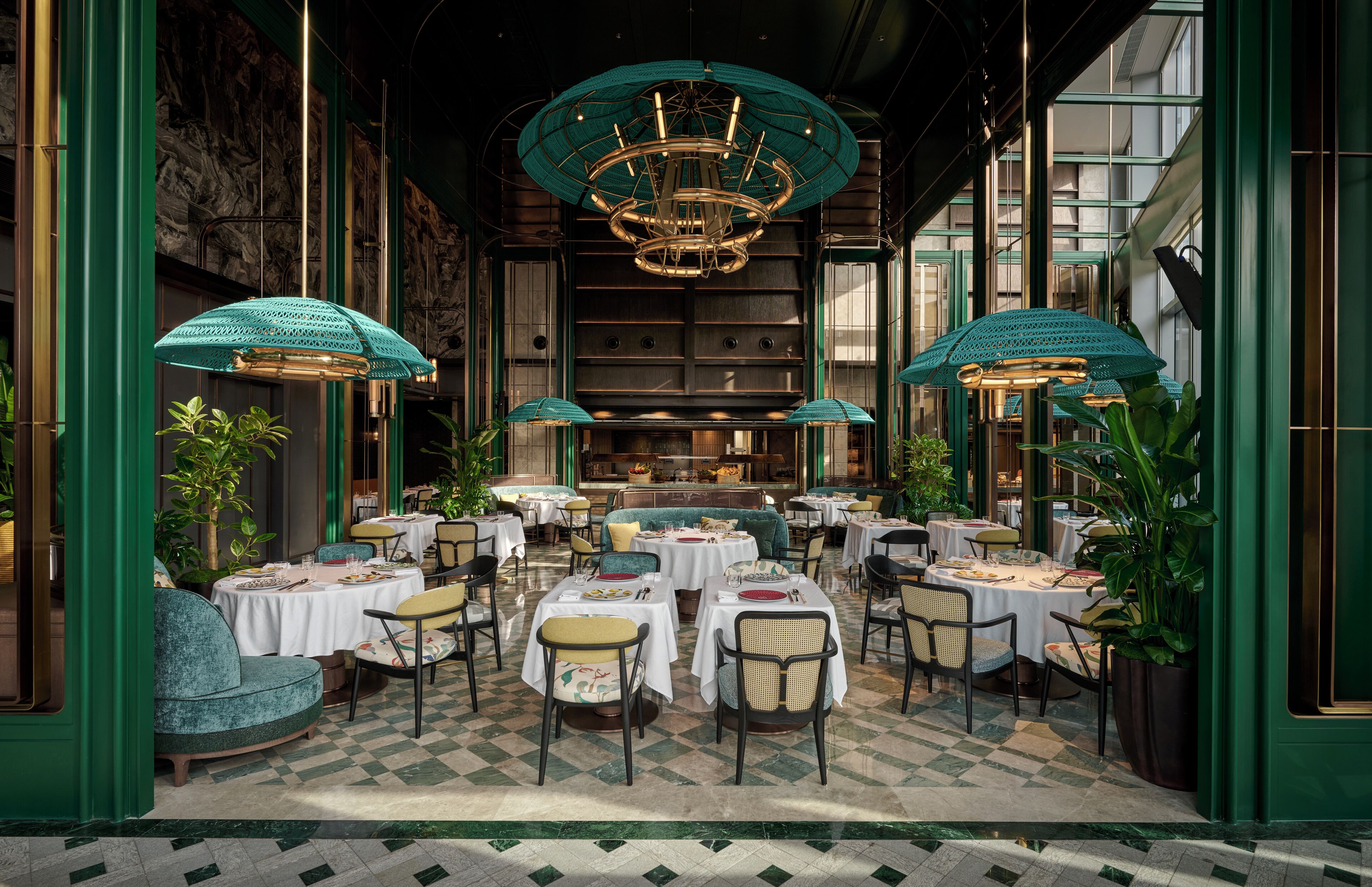 A restaurant with round tables, chairs, and a chandelier.