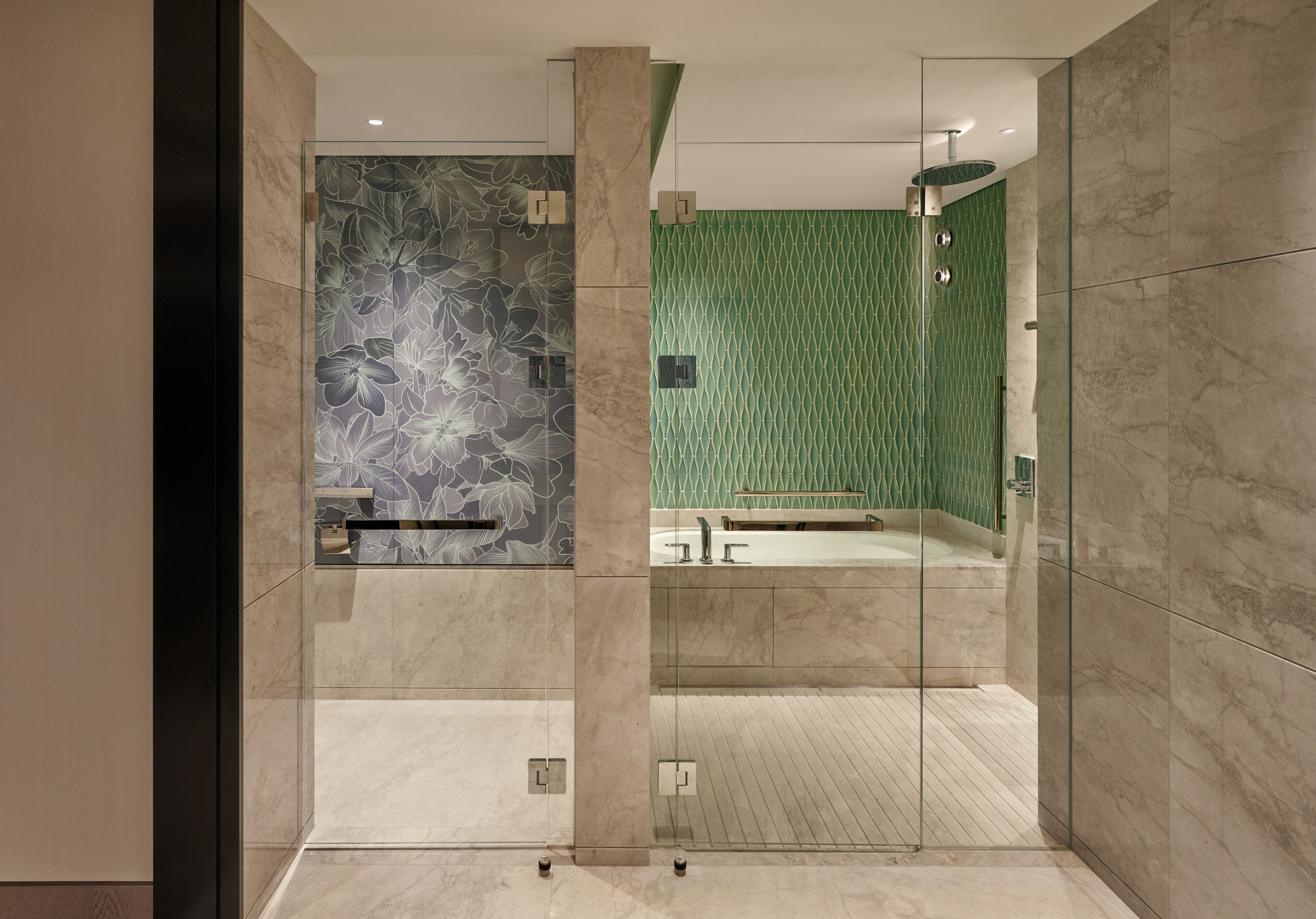A modern bathroom with a glass shower enclosure, a marble-tiled floor, and a green patterned wall.